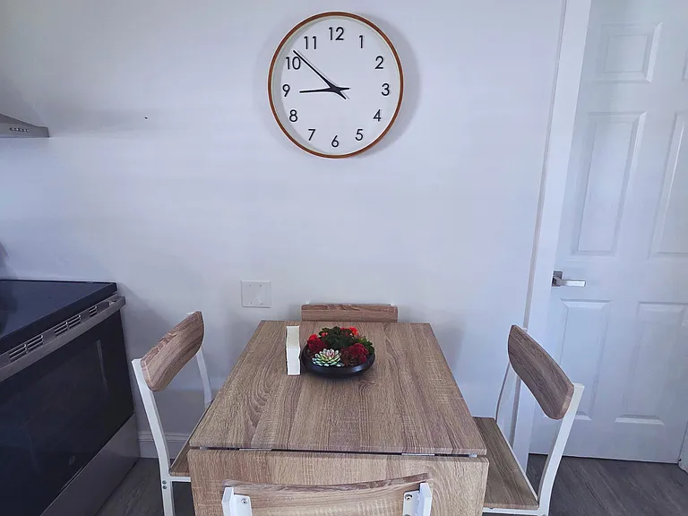 Cozy dining space with seating for 4 and a decorative clock