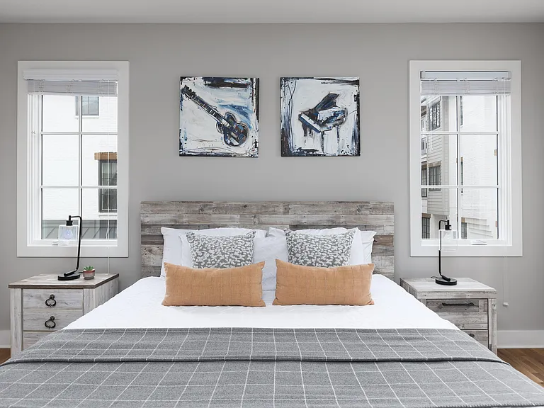Primary bedroom on the 2nd floor with a king bed, Smart TV, ensuite bath, and room darkening shades. Includes a large walk-in closet. Tastefully decorated with high-end modern furnishings.