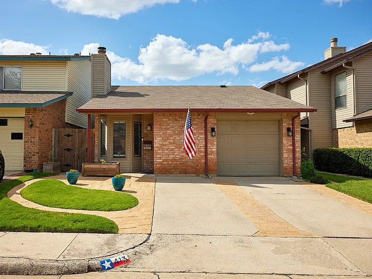 Tri-level home featuring brick siding, concrete driveway, an attached garage, and roof with shingles
