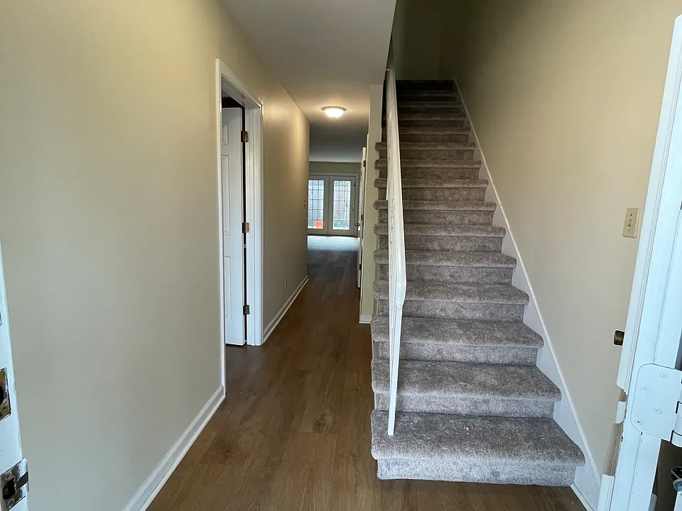 New LPV flooring throughout! Kitchen and laundry on left of hallway, living area beyond.