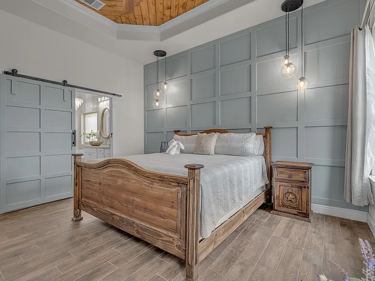Master bedroom with king bed, attached master bathroom, and large walk-in closet. Lake views from windows overlooking backyard.
