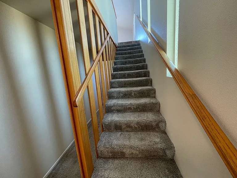 Reverse floor plan with stairway leading to living room, dining room, kitchen, primary bedroom & bathroom. Two bedrooms, bathroom & laundry room are downstairs.