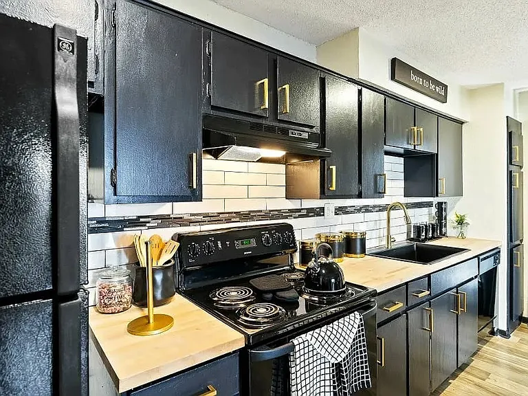 Experience the modern elegance of The WerX, featuring stylish black cabinetry and premium appliances in a spacious kitchen perfect for culinary enthusiasts. Elevate your lifestyle today and schedule a tour to see your future home!