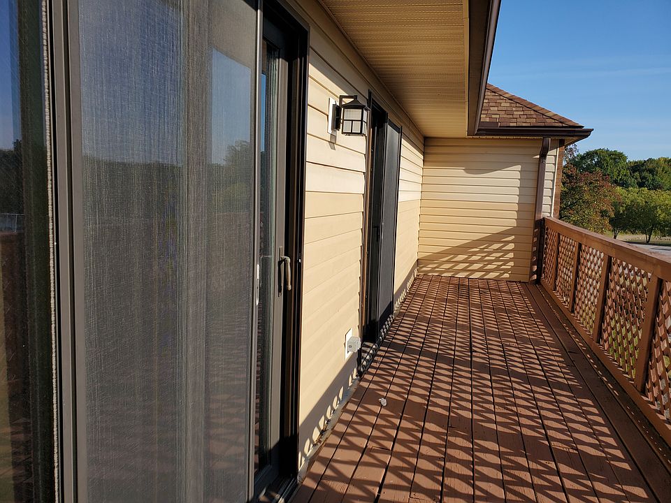 large deck with view of the tennis courts, pool and lake