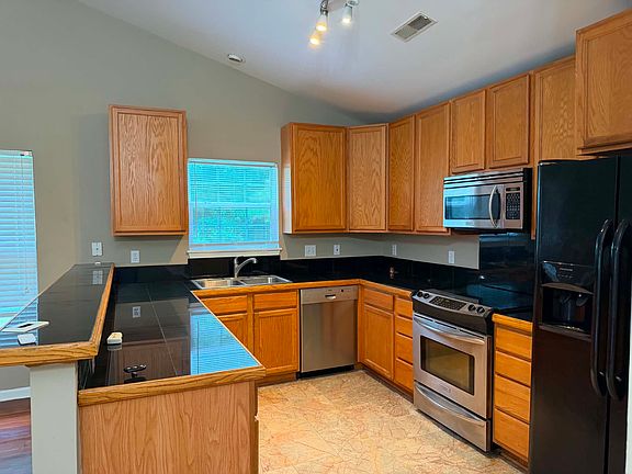Stainless steel appliances, marbled flooring, and a great view of the large backyard from the kitchen.