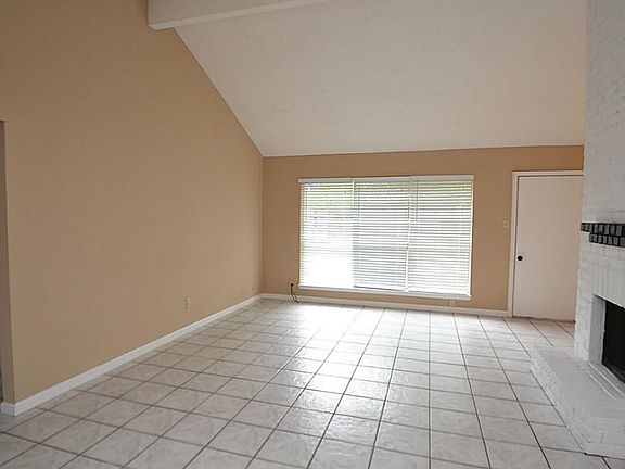 Family room featuring tile flooring, high cathedral ceilings and a wood burning fireplace.