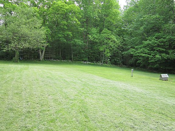 view of yard below the house, view of woods