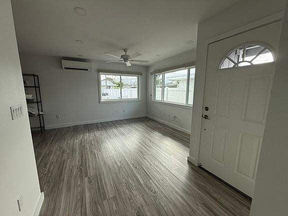 Living room with split AC, ceiling fan and blinds