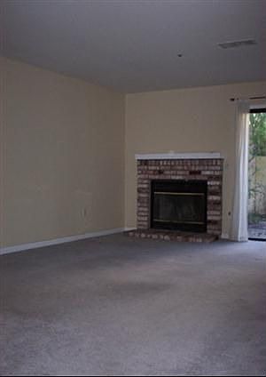 Living room with fireplace, access to enclosed patio.