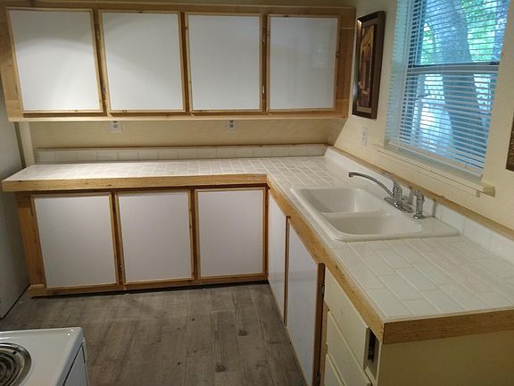Rustic looking kitchen has new tile countertops with cedar trim.