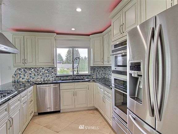 Stainless steel appliances include built-in microwave, 36" 5 burner gas stove with SS hood & 4 speed control.