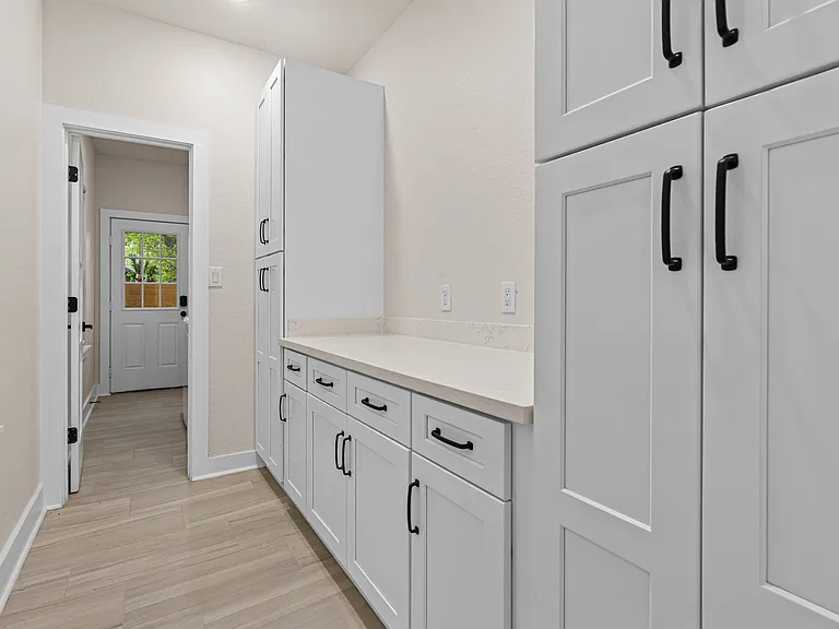 Dedicated laundry/utility area with extensive cabinet storage and a long countertop for folding and organizing.
