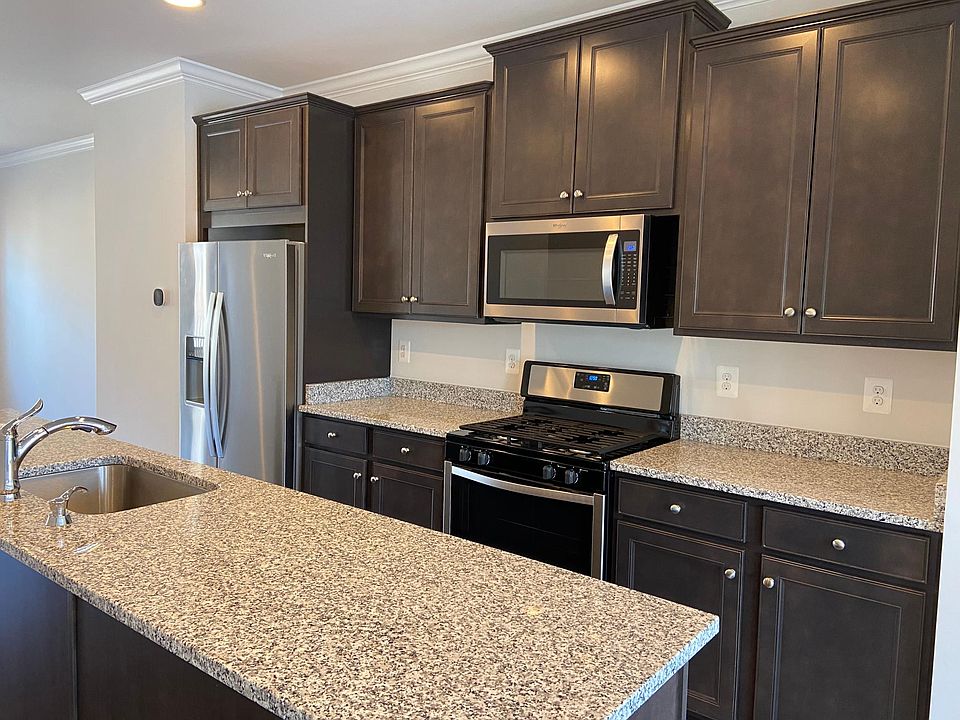 Modern kitchen with stainless steel appliances (gas range/oven, refrigerator/freezer, dishwasher and microwave), maple cabinetry, granite countertops and huge island