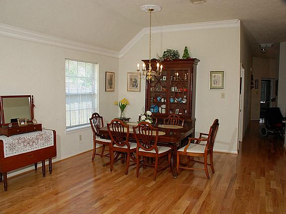 The adjacent formal living and dining room have high ceilings & beautiful hardwood floors that extend down the hall