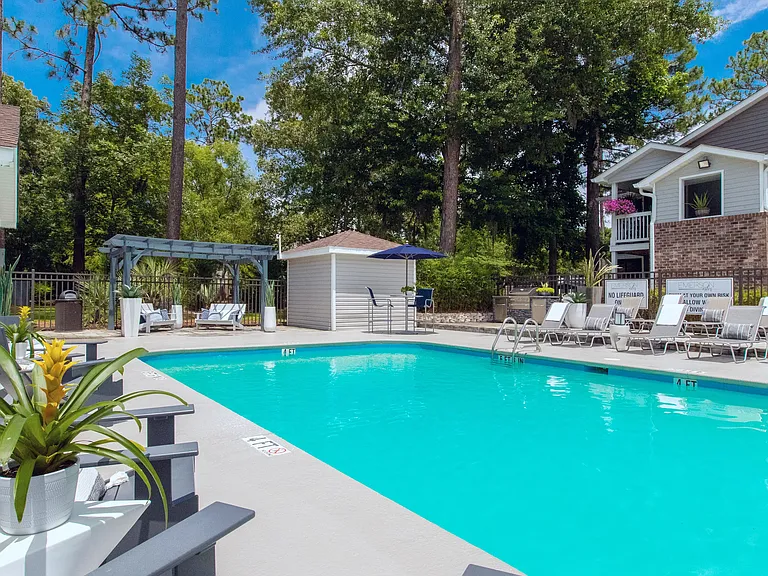 Our second community pool is a quaint, tranquil oasis featuring ample loungers and shaded tables with umbrellas on the pool deck.