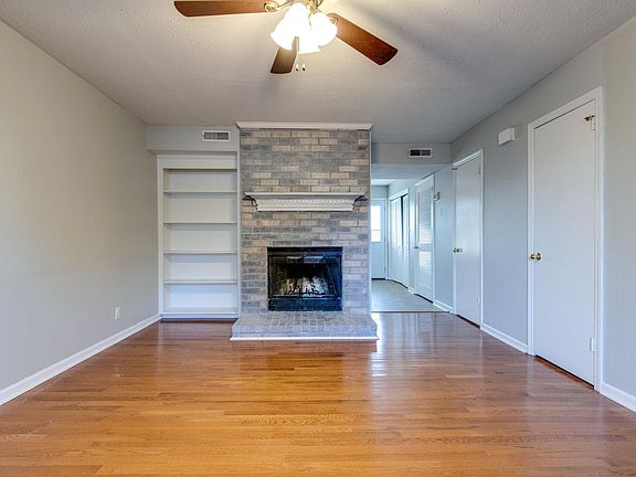 Main floor living room with wood burning fireplace and built in bookshelf