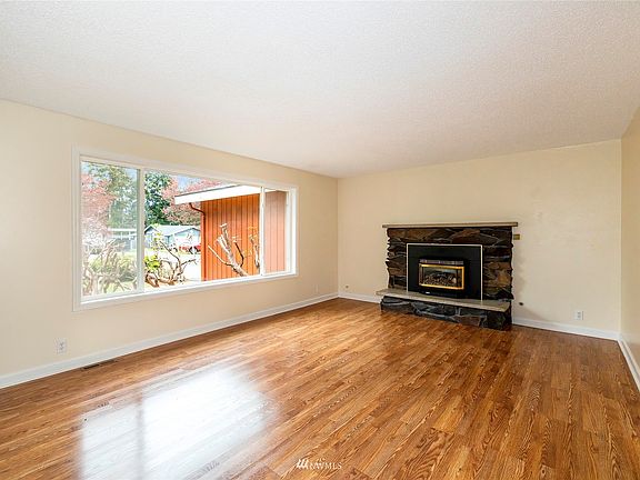 Living room with masonry fireplace and propane Quadra-Fire insert.