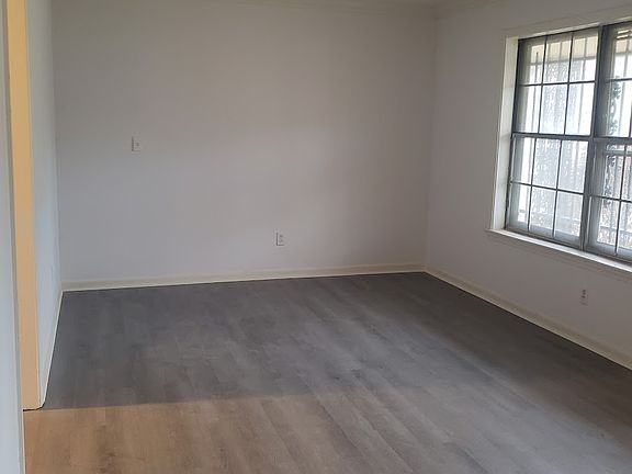 This is a view of the living room from the hallway entrance. The kitchen is on the left and the front door is on the right.