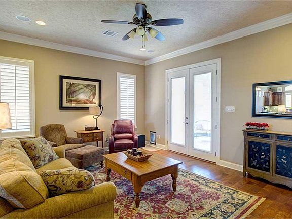 Soaring ceilings, brick facade fireplace, large windows, and French doors overlooking the outdoor li