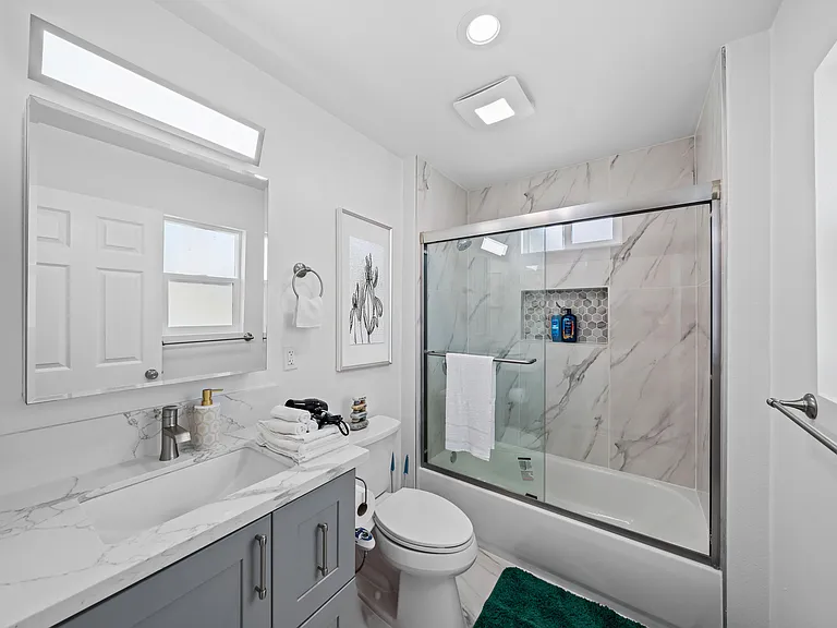 Bright, tidy bathroom with a bath tub and all the basics you need.
