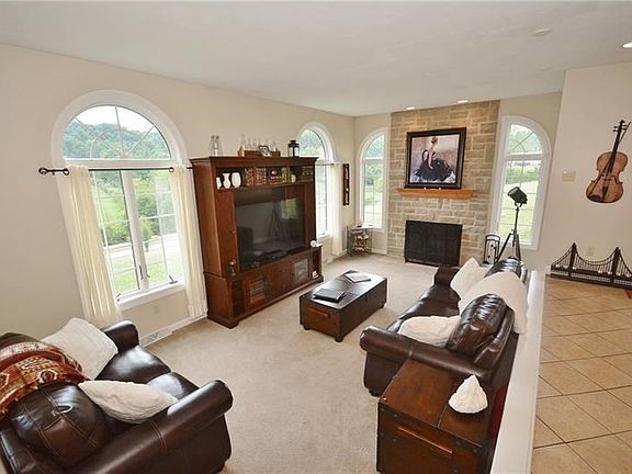 The living room with beautiful window design and floor-to-ceiling fireplace will nicely accommodate an abundance of cozy, warm f