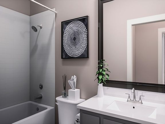 A modern bathroom with a white sink, a framed abstract artwork on the wall, and a shower enclosure i