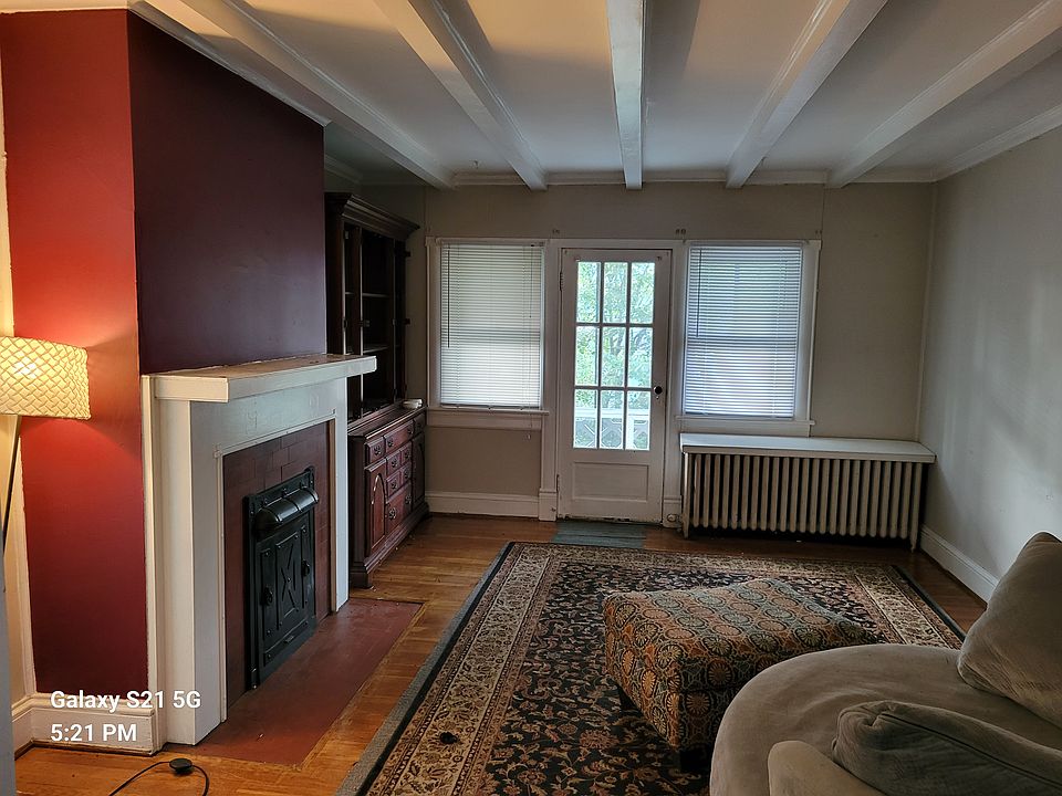 Living room with beamed ceiling. Beyond door is screen porch.