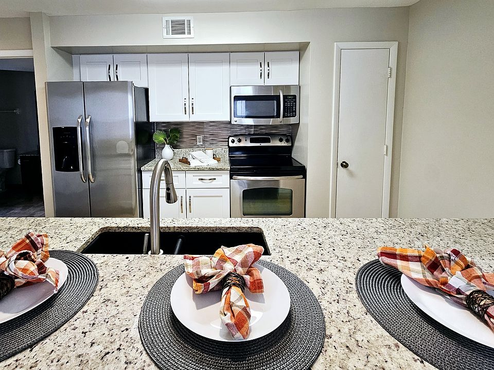 Bright kitchen with stainless steel appliances and eat in bar area open to the dining and living room.