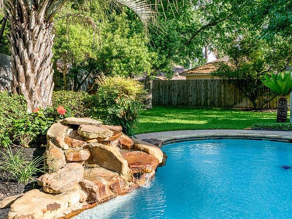 This backyard is a vacation in itself! The fountain and the tropical landscaping that accentuates it, make it a peaceful yet inviting place to spend time with friends and family. In addition, there is plenty of yard space for furry family members and