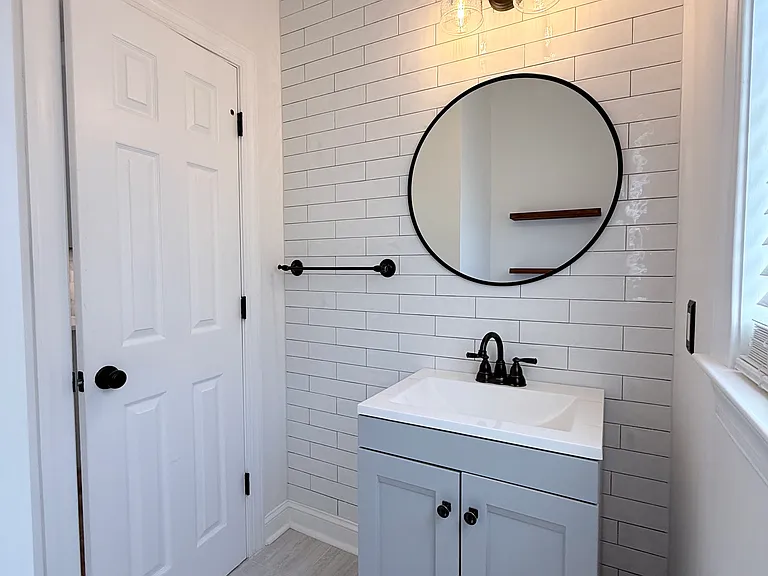 subway tile wall, updated fixtures, vanity & flooring!