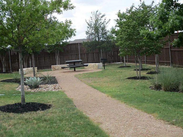 Common area with picnic table and outdoor charcoal grill