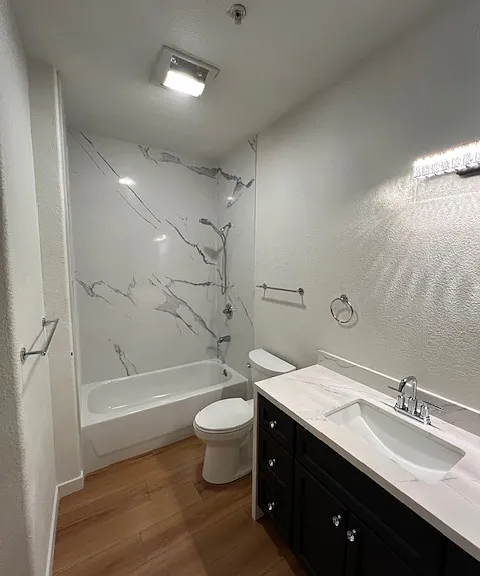 All new shower with super high ceilings in the primary bathroom.Gorgeous shower walls and countertops with wood look flooring for easy maintenance and care. Hookuops for washer and dryer in this room