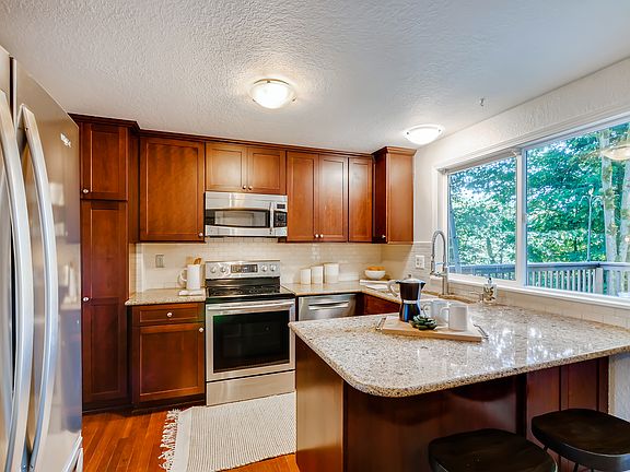 
                    Kitchen with quaint breakfast bar, double-sink with large window facing deck & yard.
                