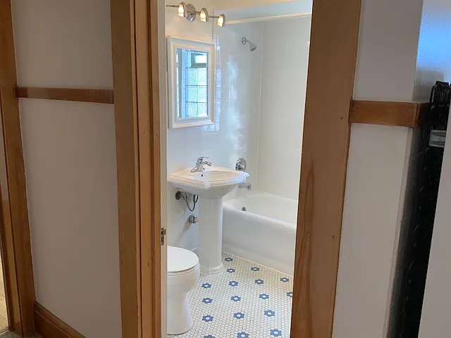 Bright, cheery bathroom with new pedestal sink and fixtures. Contemporary lighting.