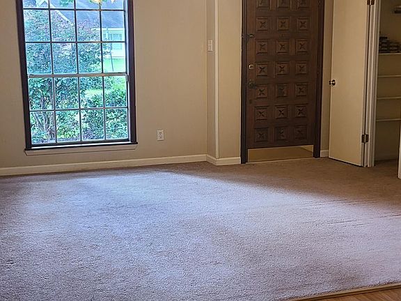 Living room with ceiling fan, floor to ceiling window and storage closet with shelving