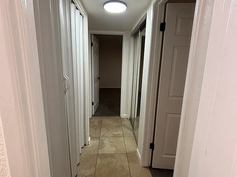 Downstairs hallway with 2 bedrooms and laundry center