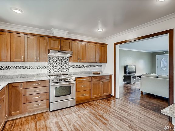 Beautiful wood adorned entryway welcomes you to the sparkling spacious kitchen with recessed lighting.