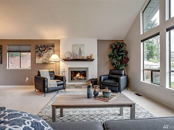 The living room also features a lovely white brick wall and cozy wood burning fireplace. 