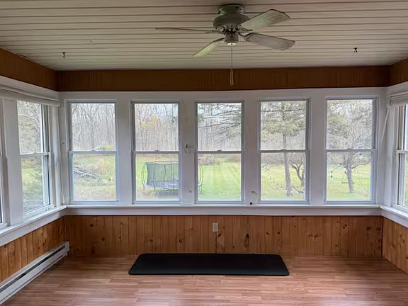 Sun-filled enclosed porch with panoramic views _ ideal for a home gym, reading nook, or peaceful morning coffee spot.