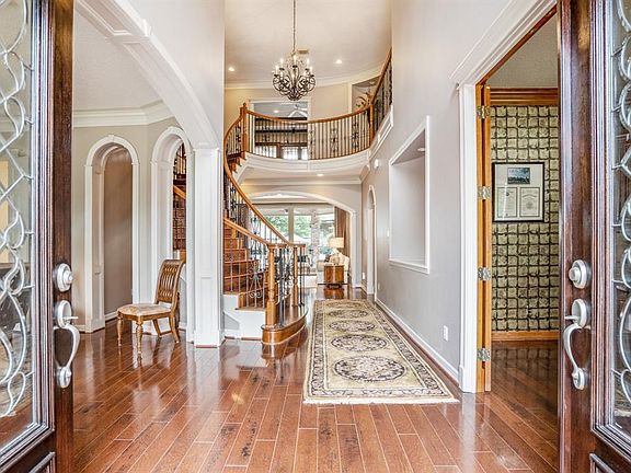 Double wood and lead glass doors lead into an immaculate thoughtfully custom designed home.