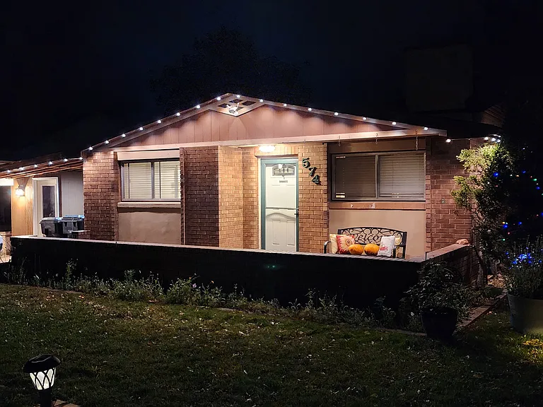 Front of home with lights on.