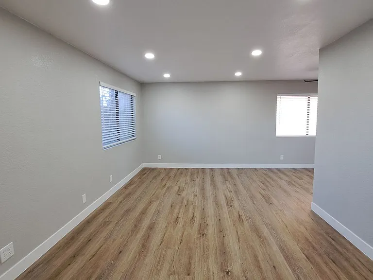 Luxury Vinyl Plank w/ modern baseboard and recess light