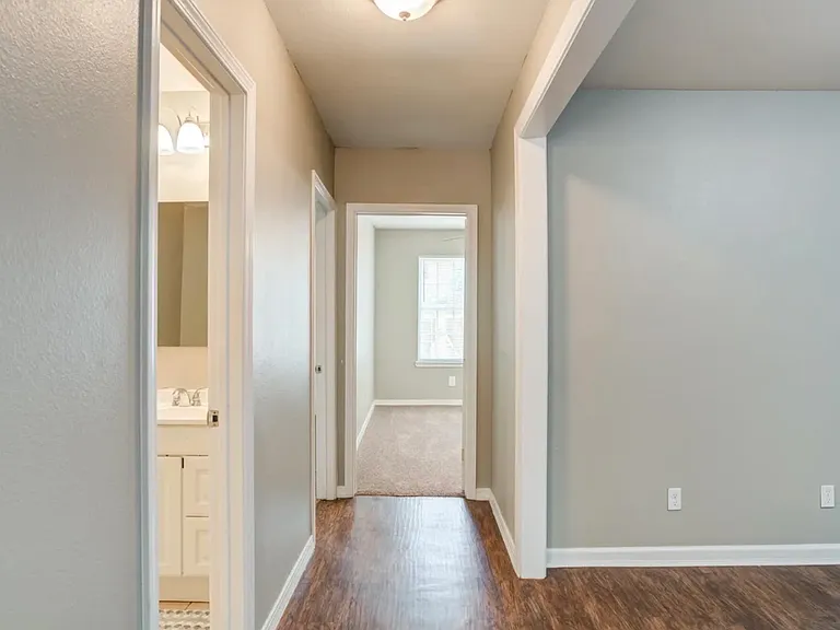 Central Hallway _ Convenient hallway leading to the cozy Garden Suite, its dedicated private bathroom to the left, and the shared kitchen to the right. Thoughtfully designed for easy access while maintaining privacy for all residents.