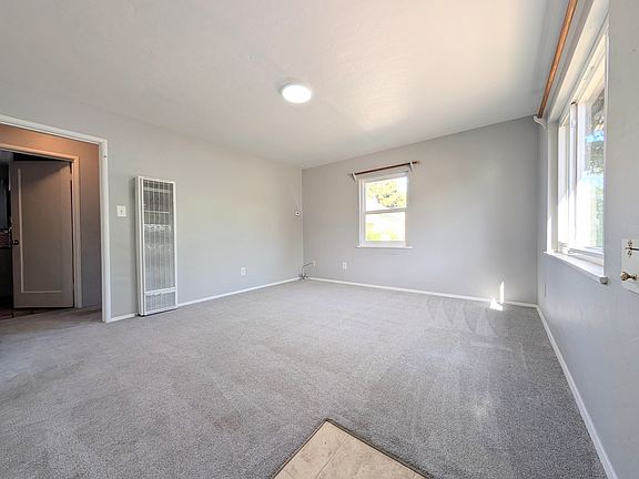 POV from front door looking at living room. Kitchen on left, straight through threshold of door is the bathroom. To the right of the bathroom is the first bedroom. On the left of the bathroom is the stairs up to the second bedroom and large walk-in closet