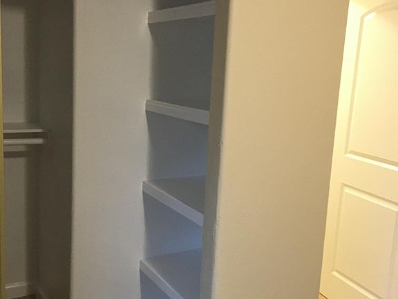 Bedroom walk in closet with convenient shelving