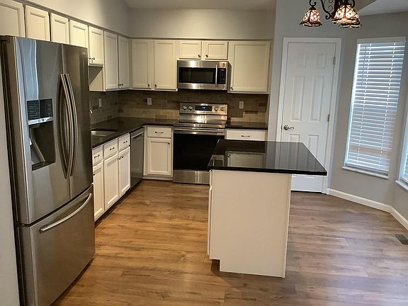 Stainless steel appliances and granite counter tops with island.