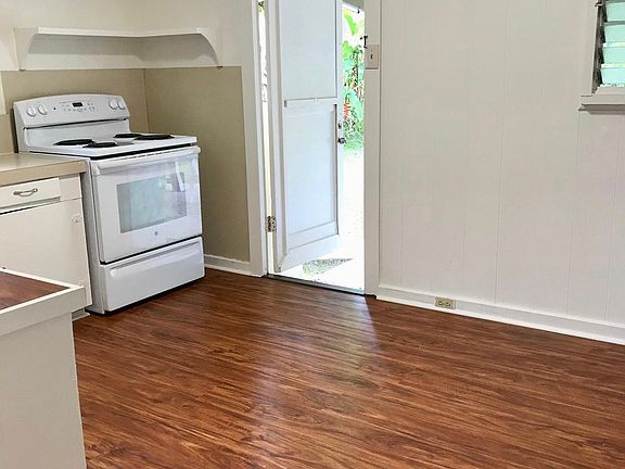 Ole style Hawaiian kitchen - lots of cabinets, windows, door leading to the back yard.