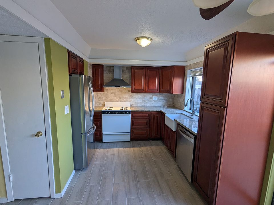 Kitchen with new cabinets, granite countertop, marble back splash, farm sink, range hood and French door refrigerator.