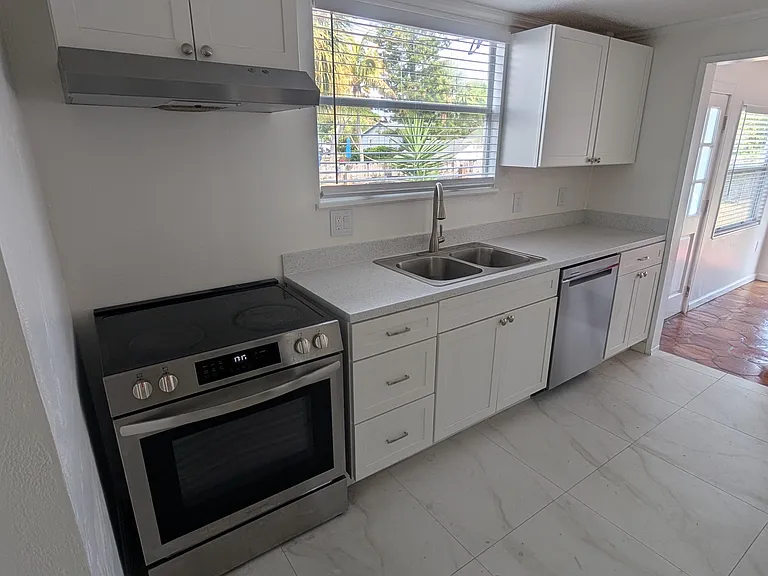 Kitchen Left side. More cabinets and Fridge on right side.