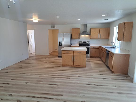 Kitchen with central workstation and room for a kitchen table. Stainless steel appliances.